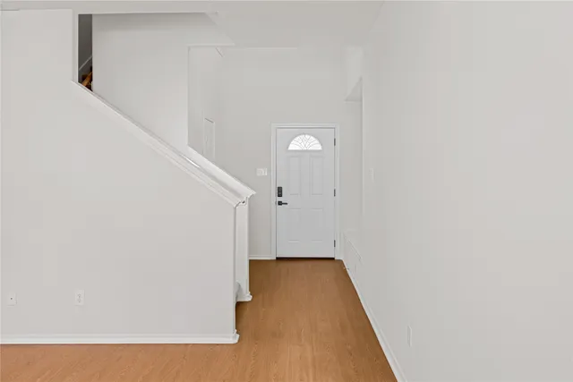 a view of a room with wooden floor and white walls