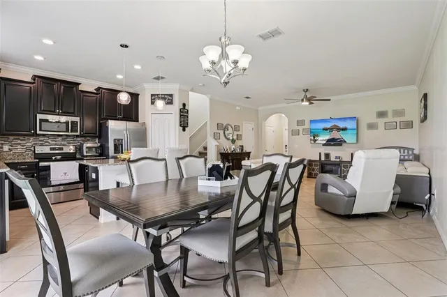 a kitchen with stainless steel appliances kitchen island granite countertop a kitchen island hardwood floor sink stove dining table and chairs