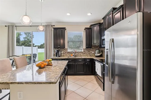 a kitchen with stainless steel appliances granite countertop a refrigerator and a stove top oven