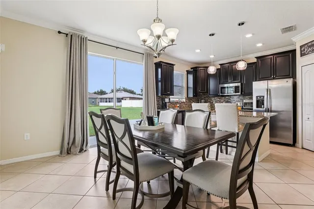 a view of a dining room with furniture a chandelier and wooden floor