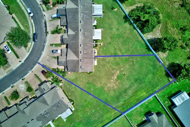 an aerial view of a residential houses with outdoor space