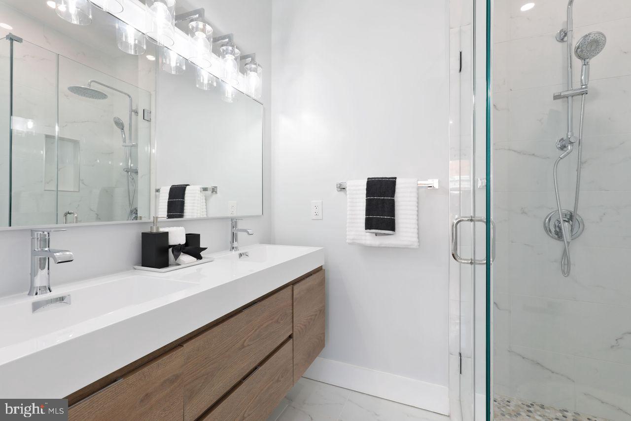 1023 Florida Avenue Northeast Washington, DC 20002 - Photo 14 of 24 a bathroom with a double vanity sink a mirror and shower