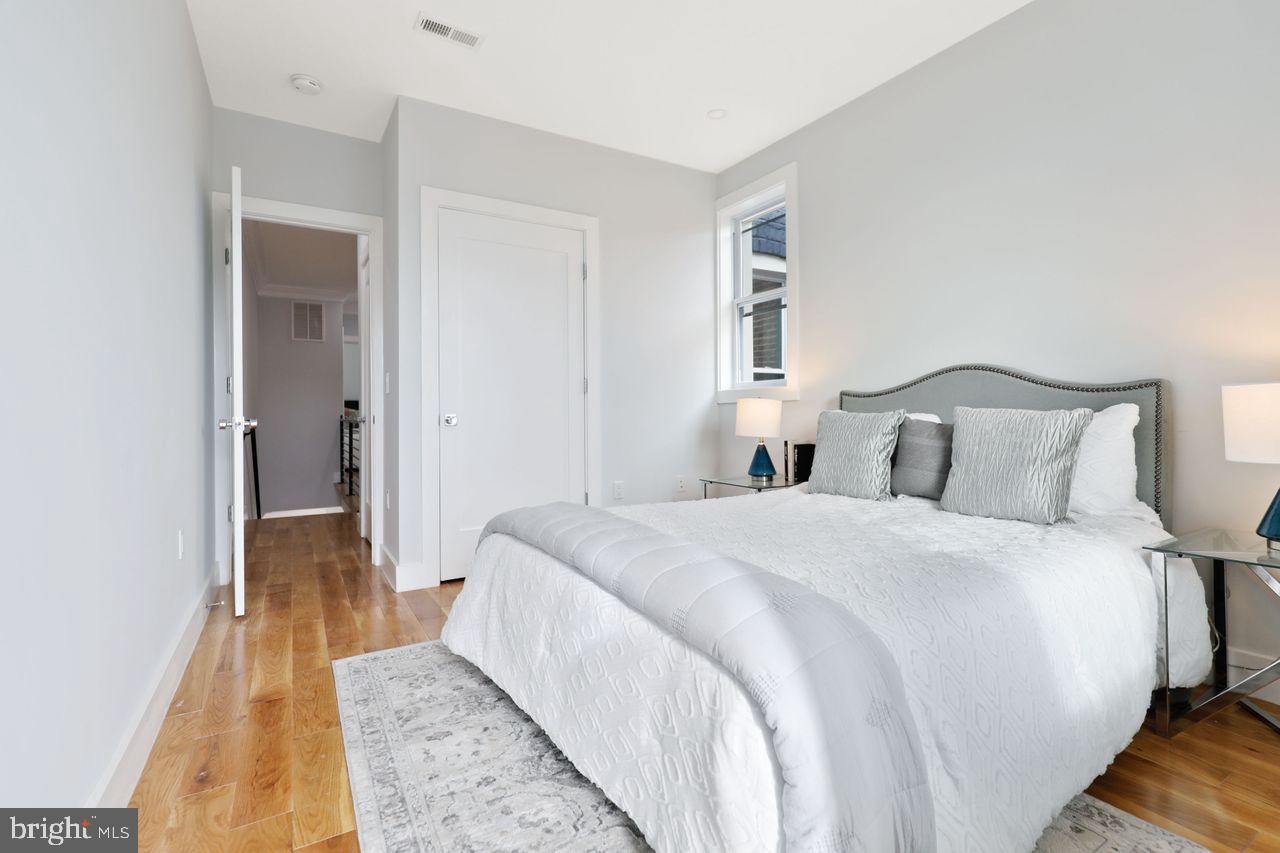 1023 Florida Avenue Northeast Washington, DC 20002 - Photo 2 of 24 a bedroom with a bed and wooden floor