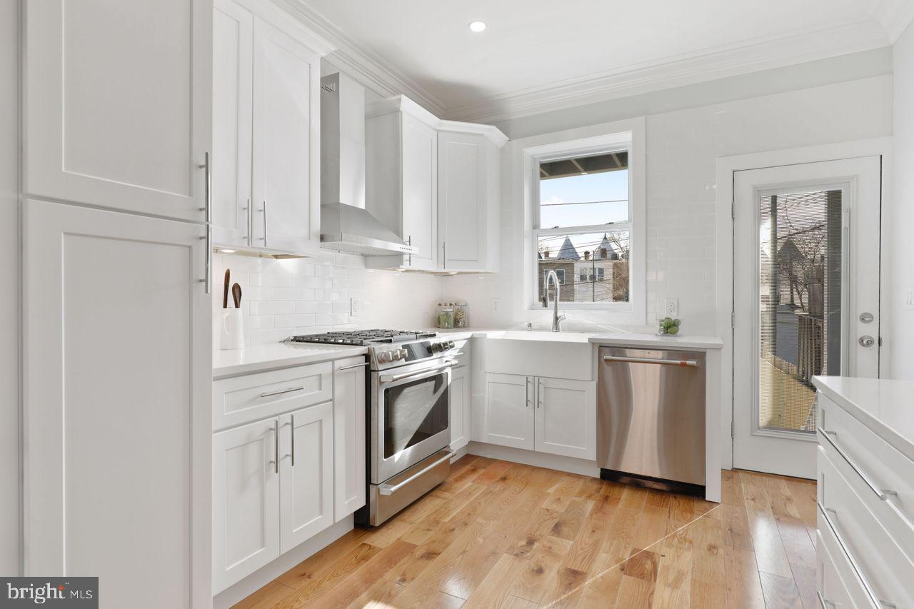 1023 Florida Avenue Northeast Washington, DC 20002 - Photo 21 of 24 a kitchen with white cabinets and white appliances