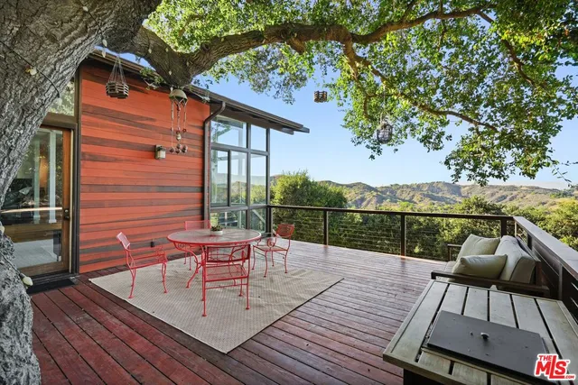 a balcony with wooden floor table and chairs