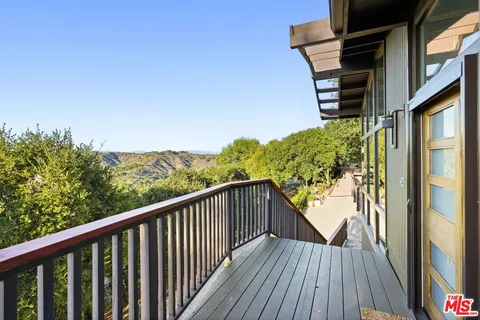 a living room with furniture fireplace and large windows