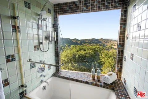 a open kitchen with stainless steel appliances granite countertop a stove a sink and a microwave