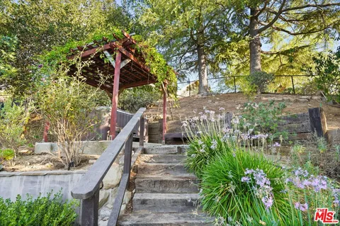a living room with furniture large windows and wooden floor