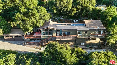 an aerial view of a house with swimming pool garden and patio