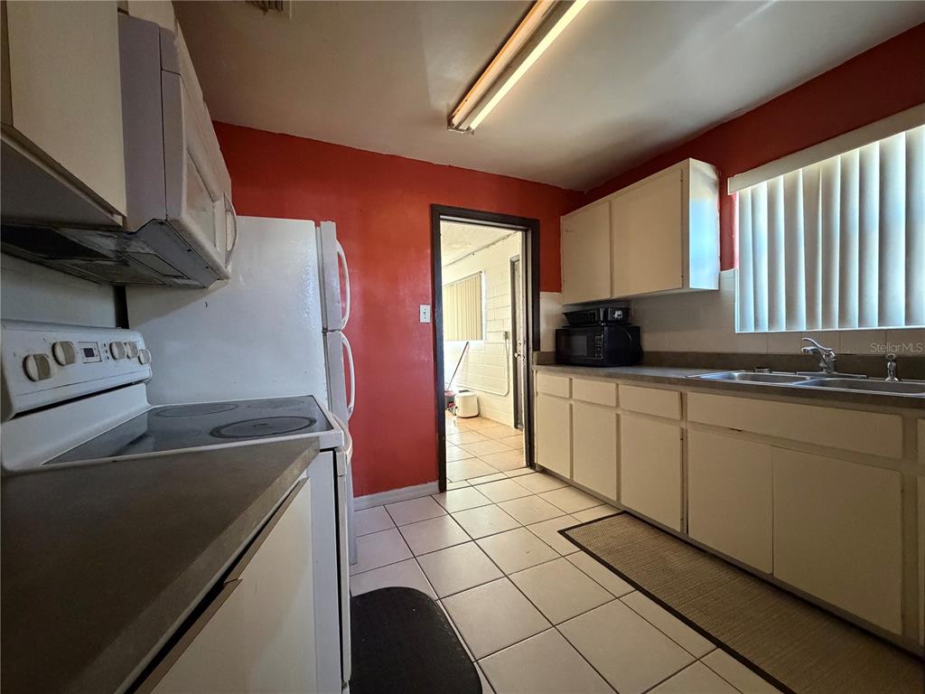 348 Pleasant Street Daytona Beach, FL 32114 - Photo 5 of 12 a kitchen with stainless steel appliances granite countertop a sink a stove and a refrigerator