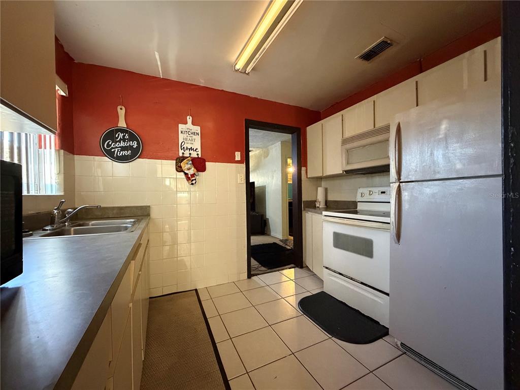 348 Pleasant Street Daytona Beach, FL 32114 - Photo 6 of 12 a kitchen with a refrigerator and a sink
