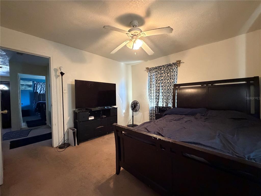 348 Pleasant Street Daytona Beach, FL 32114 - Photo 7 of 12 a bedroom with a bed and a chandelier