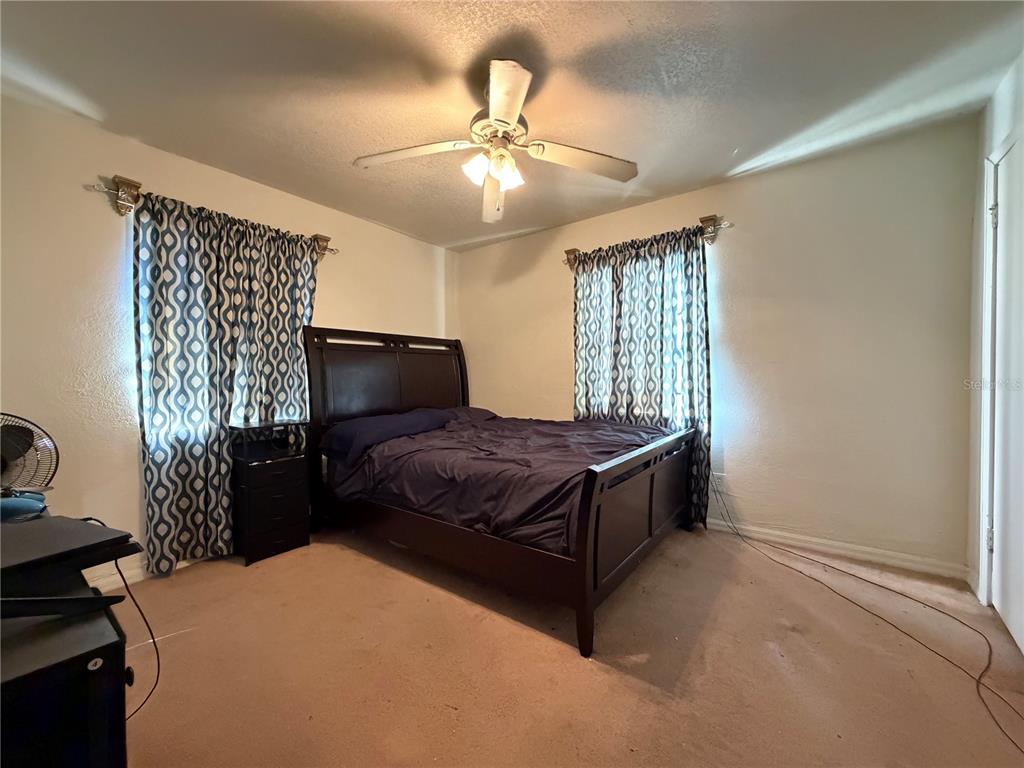 348 Pleasant Street Daytona Beach, FL 32114 - Photo 8 of 12 a bedroom with a bed and a chandelier
