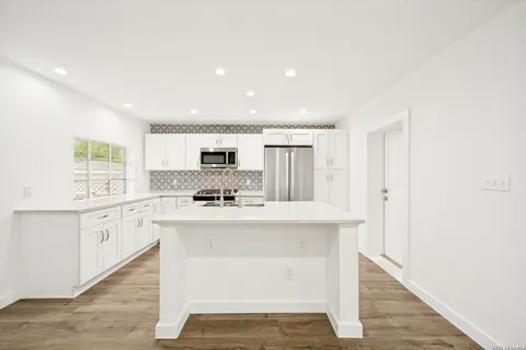 a kitchen with white cabinets sink and stainless steel appliances