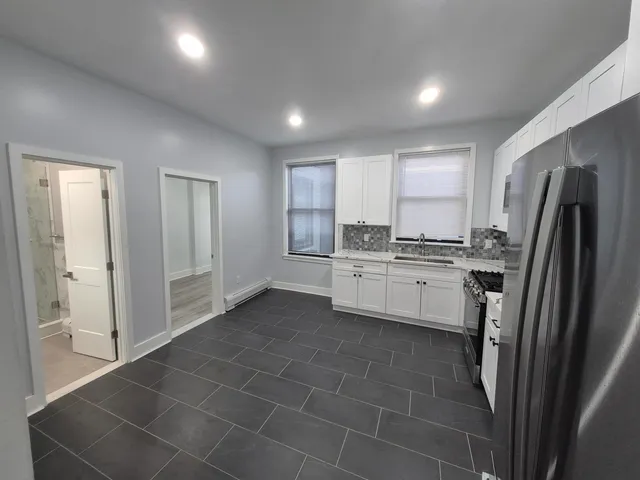 a large white kitchen with white cabinets and a stove
