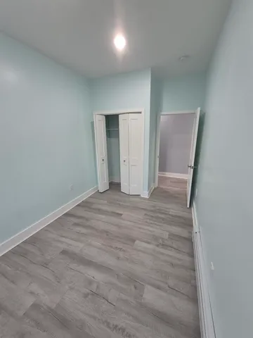 an empty room with wooden floor and mirror