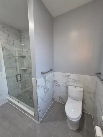 a bathroom with a toilet and a shower