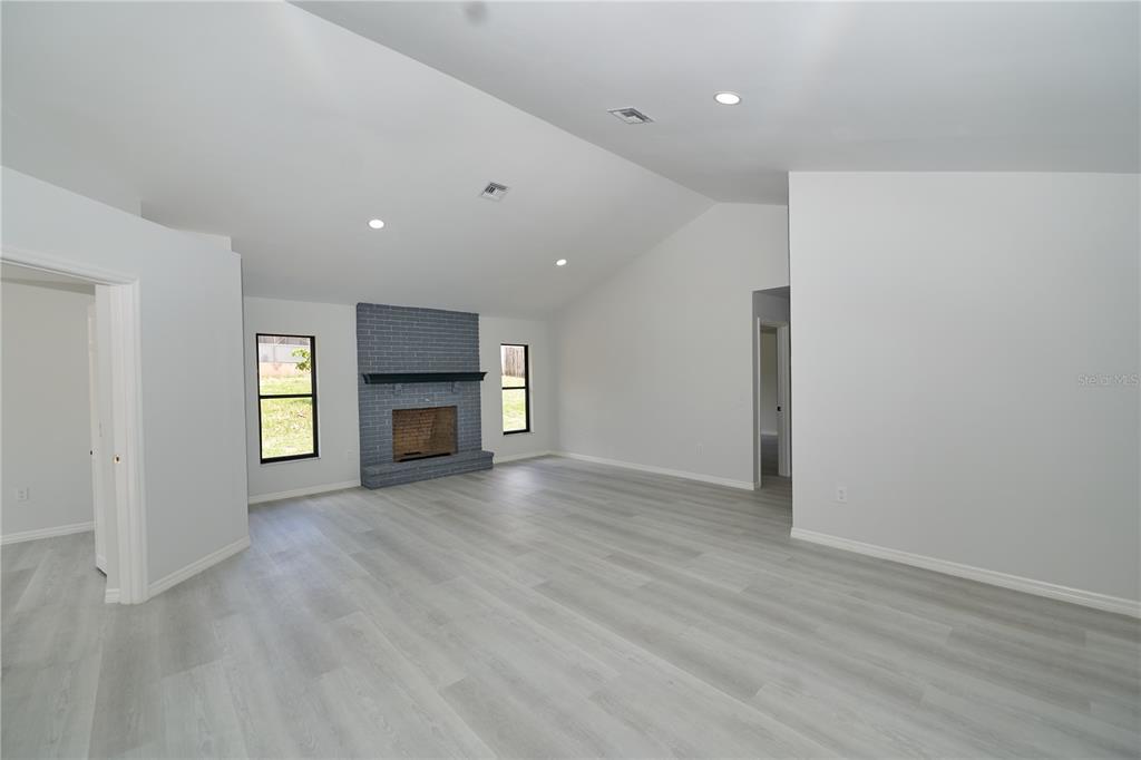 119 Ridgecrest Drive Eustis, FL 32726 - Photo 20 of 52 an empty room with wooden floor and fireplace