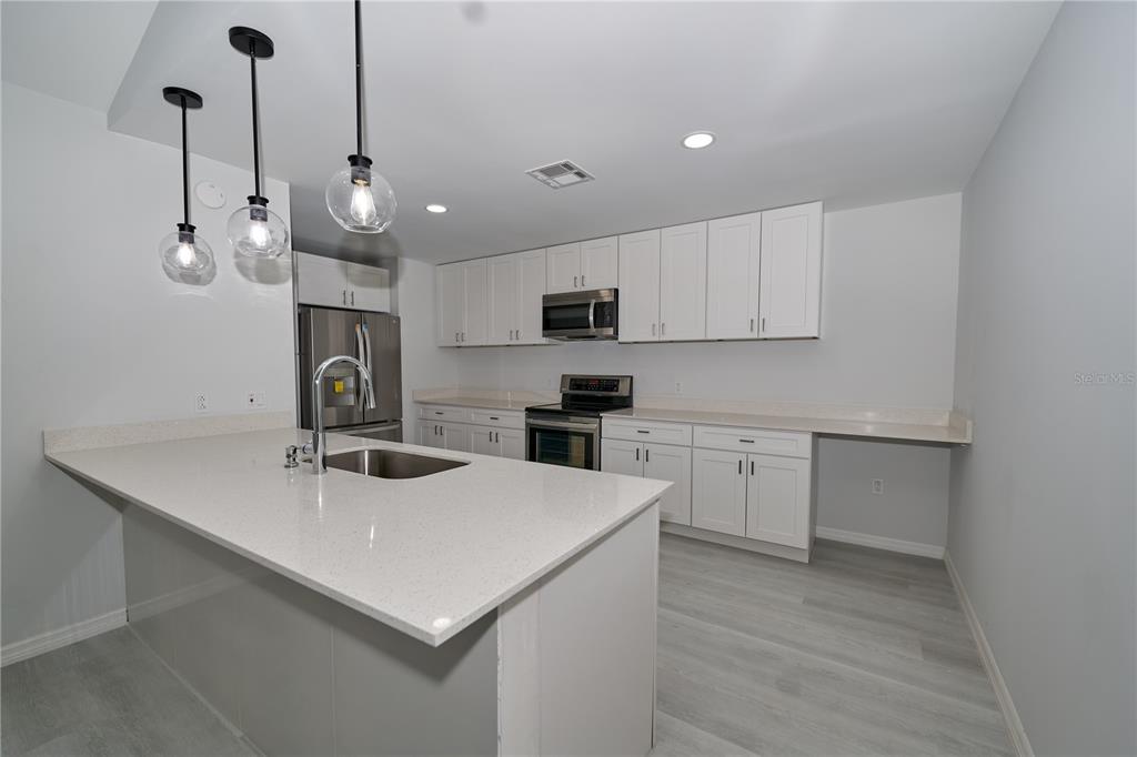 119 Ridgecrest Drive Eustis, FL 32726 - Photo 26 of 52 a kitchen with a sink a microwave and cabinets