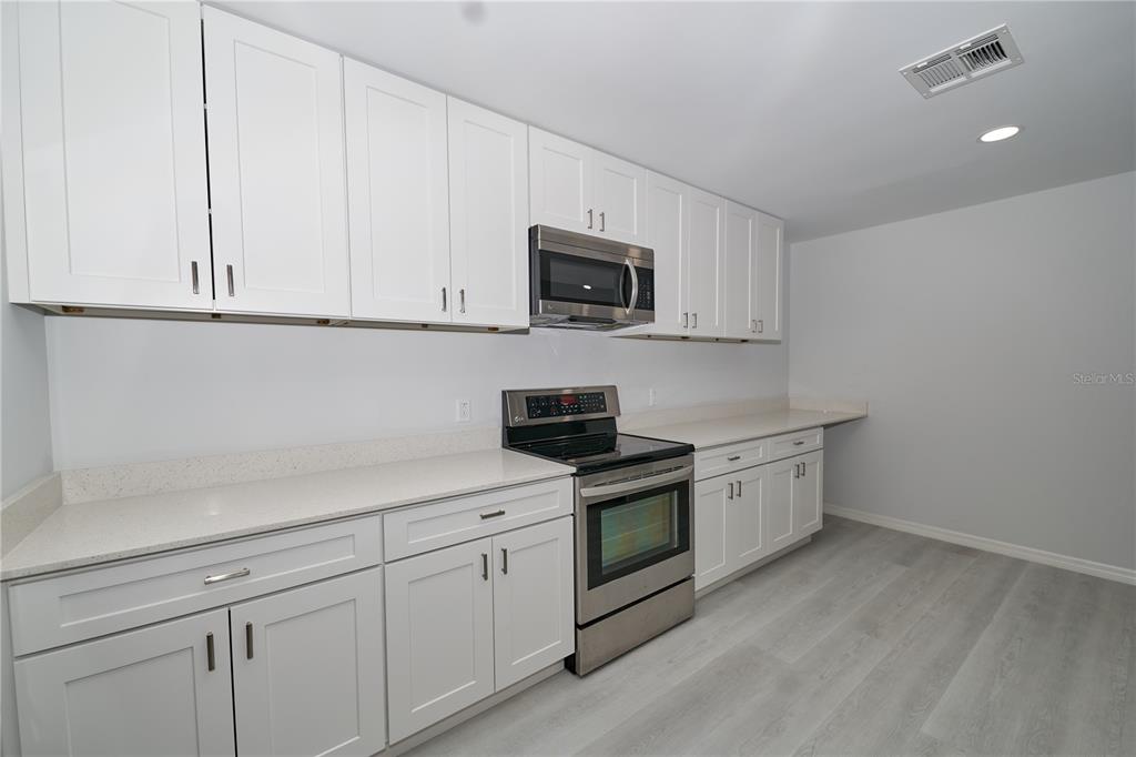 119 Ridgecrest Drive Eustis, FL 32726 - Photo 31 of 52 a kitchen with white cabinets and stainless steel appliances