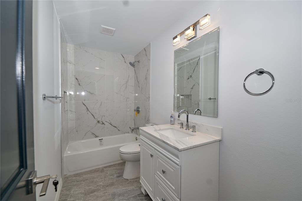 119 Ridgecrest Drive Eustis, FL 32726 - Photo 38 of 52 a bathroom with a granite countertop sink a toilet and bathtub