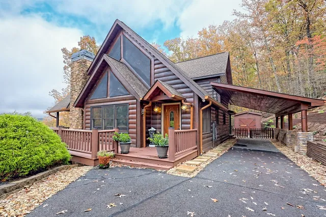 a living room with a fireplace a flat screen tv and a floor to ceiling window