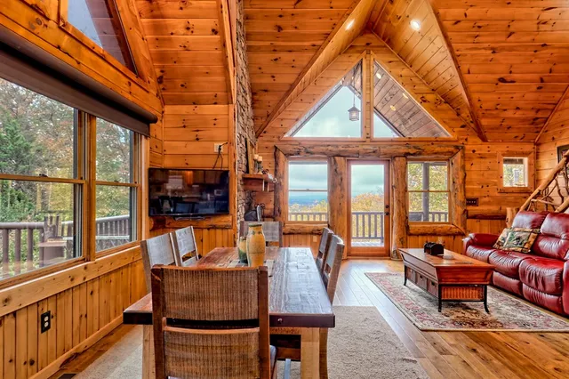 a living room with furniture a fireplace and a floor to ceiling window