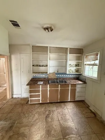 a kitchen with kitchen island granite countertop a stove a sink and a refrigerator