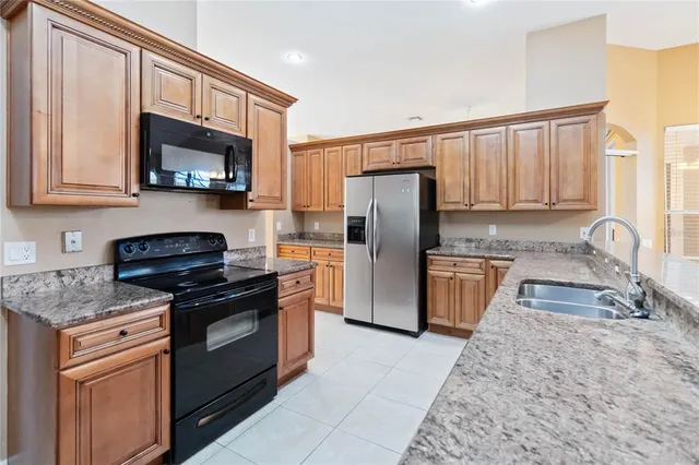 a kitchen with stainless steel appliances granite countertop a stove a sink and a microwave