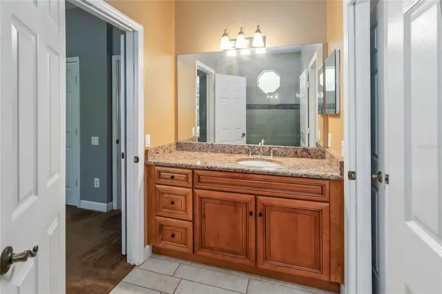 a bathroom with a granite countertop sink vanity and mirror