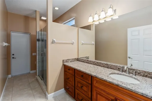 a bathroom with a granite countertop double vanity sink and a mirror