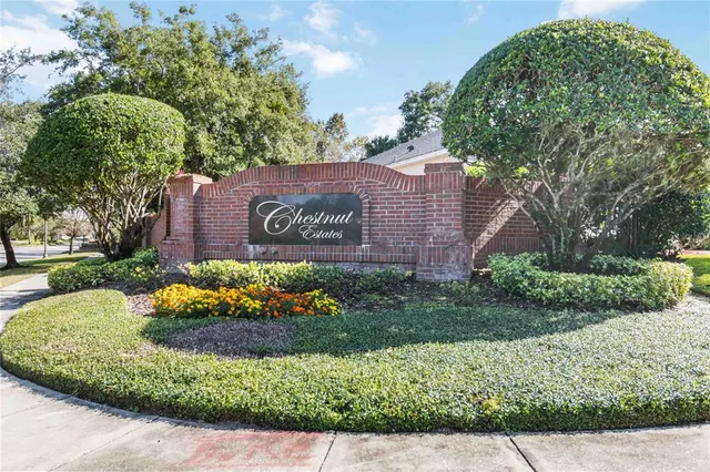 a sign that is sitting in front of a brick house