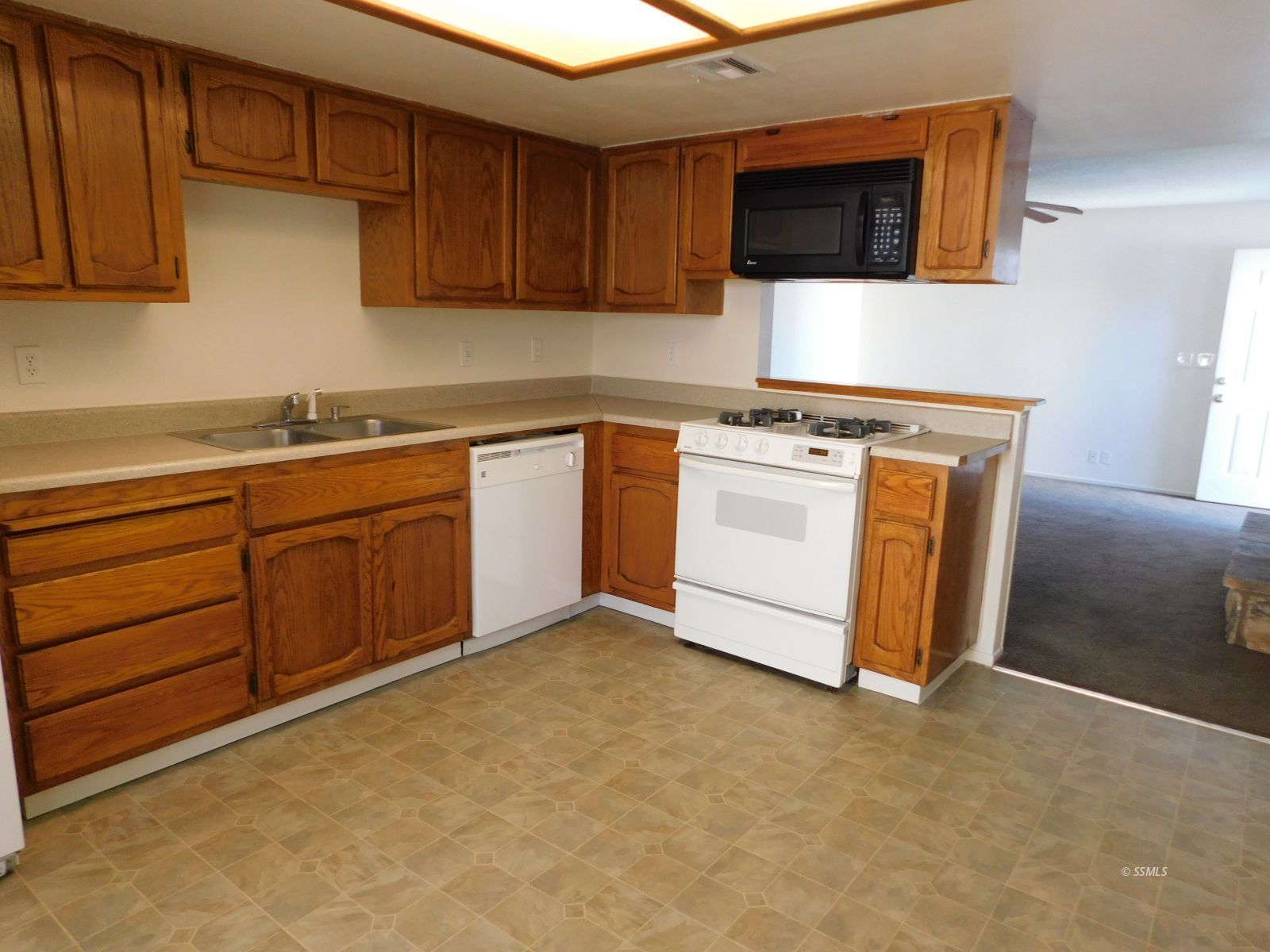 941 West Perdew Avenue Ridgecrest, CA 93555 - Photo 6 of 12 a kitchen with stainless steel appliances granite countertop a stove a sink and a microwave