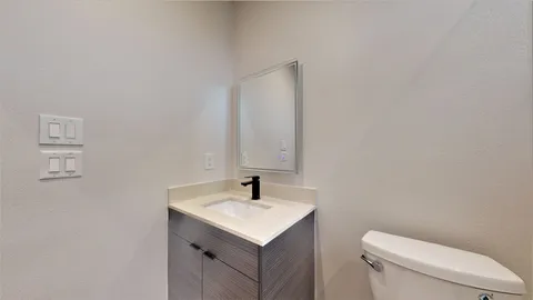 a bathroom with a toilet sink and mirror