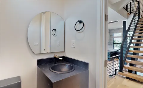 a view of staircase with lots of frames on wall and a window