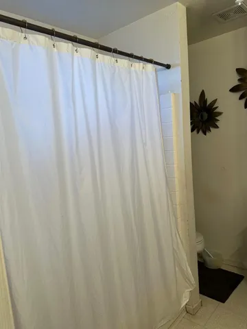 a bedroom with a bed and a flat tv screen on dresser