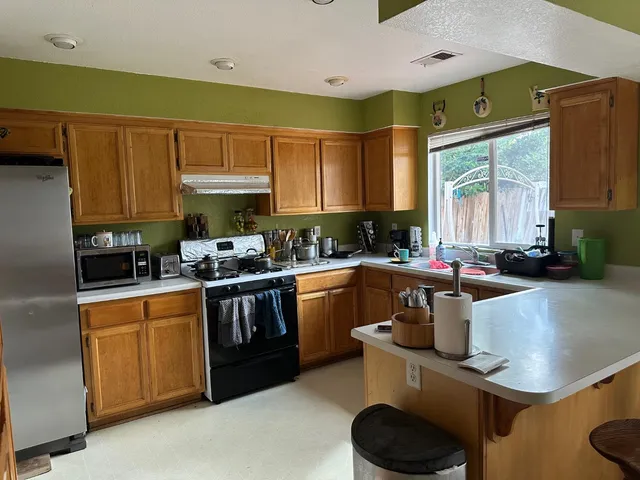 a kitchen with a stove a sink and a cabinets