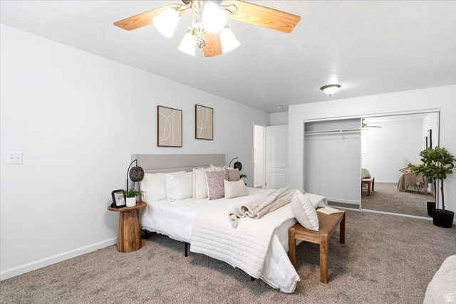 1341 29th Street Ogden, UT 84403 - Photo 17 of 37 Carpeted bedroom featuring a light gray upholstered headboard, white walls, and a ceiling fan with light fixture