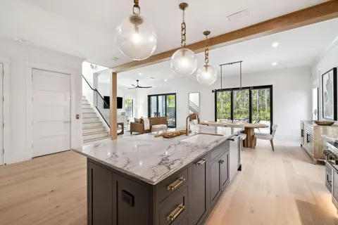 a dining room with furniture a chandelier and wooden floor