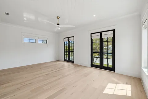 a view of an empty room with a window and wooden floor