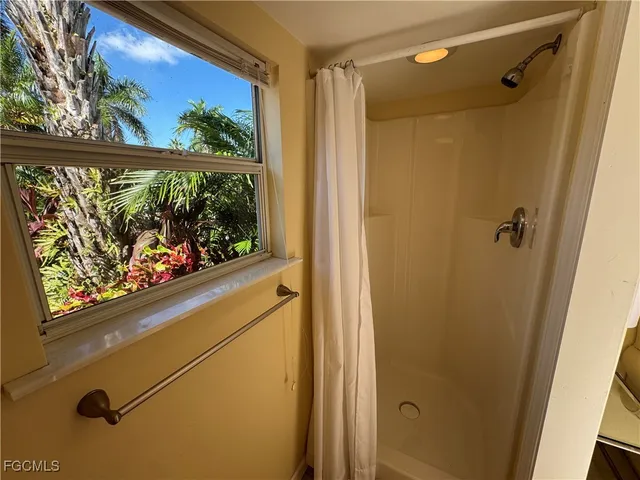 a bathroom with a window and a shower