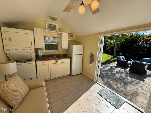 a kitchen with a refrigerator a microwave oven dining table chairs and a large window