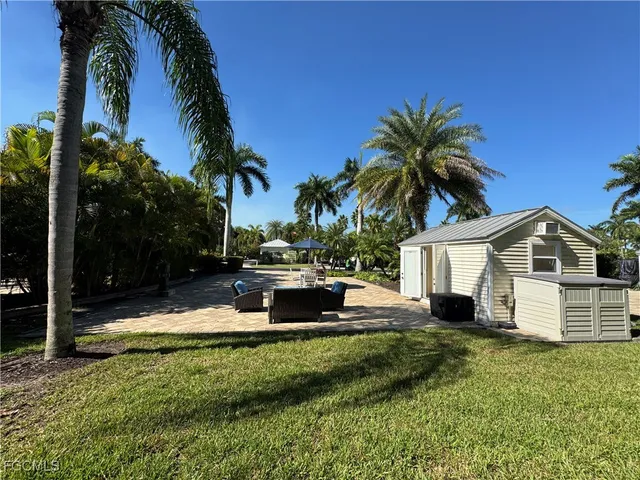 a front view of a house with a garden and tree