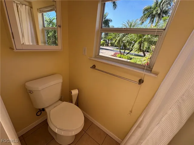 a white toilet sitting next to a window