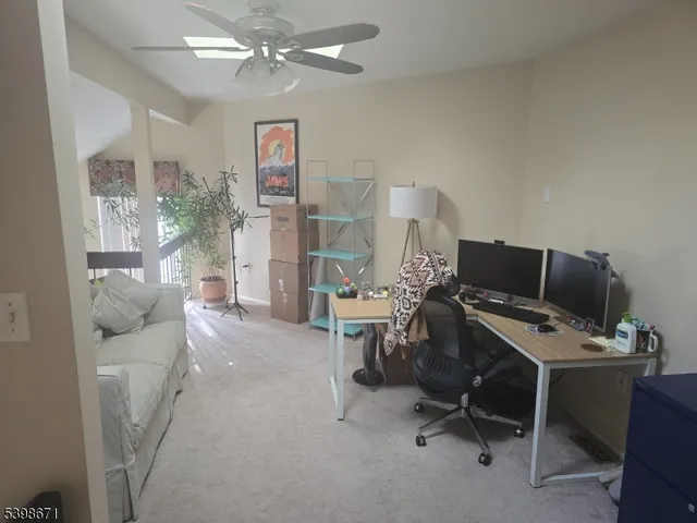 a view of a workspace with furniture and a window