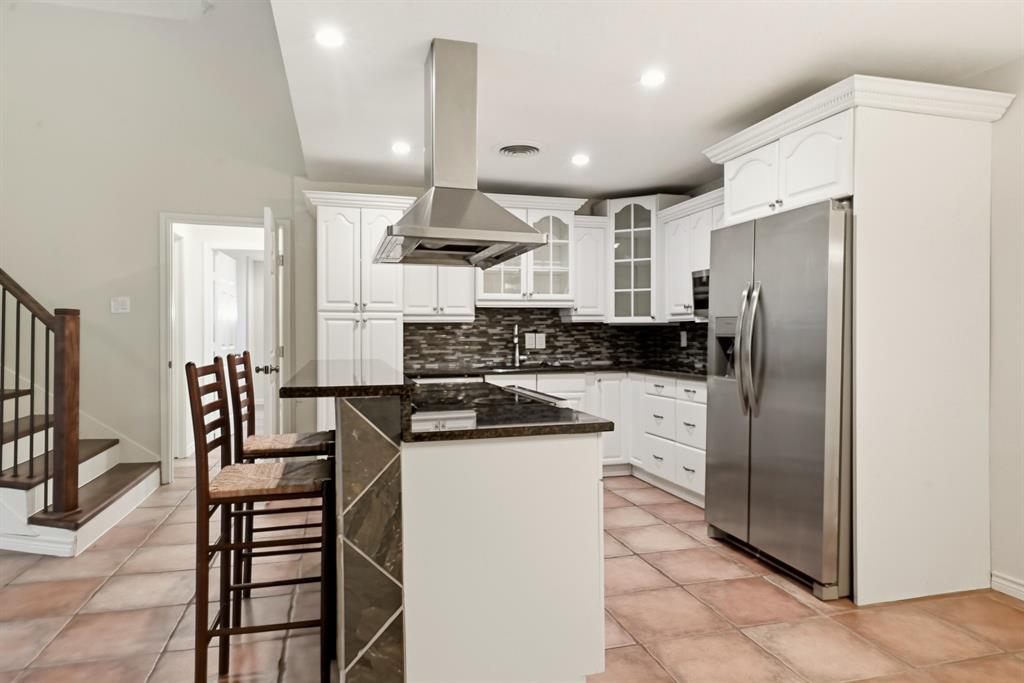 7354 Walling Lane Dallas, TX 75231 - Photo 7 of 28 a kitchen with stainless steel appliances kitchen island granite countertop a refrigerator a stove a sink and white cabinets