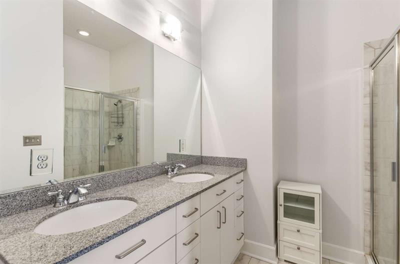 384 Ralph McGill Boulevard Northeast, Unit 313 Atlanta, GA 30312 - Photo 15 of 31 a bathroom with a granite countertop sink and a mirror