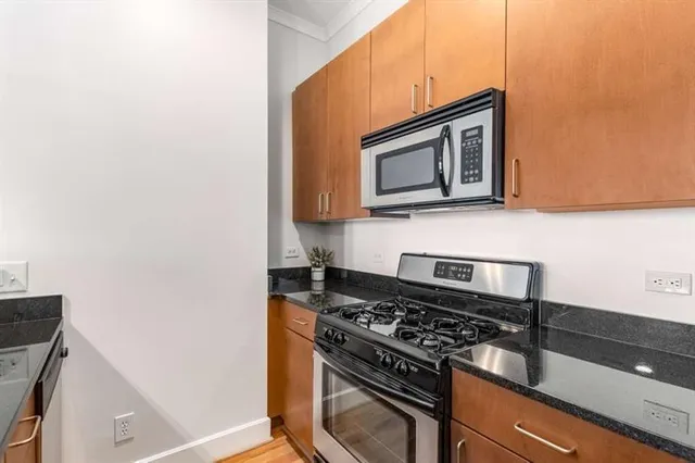 a kitchen with granite countertop a sink and white cabinets