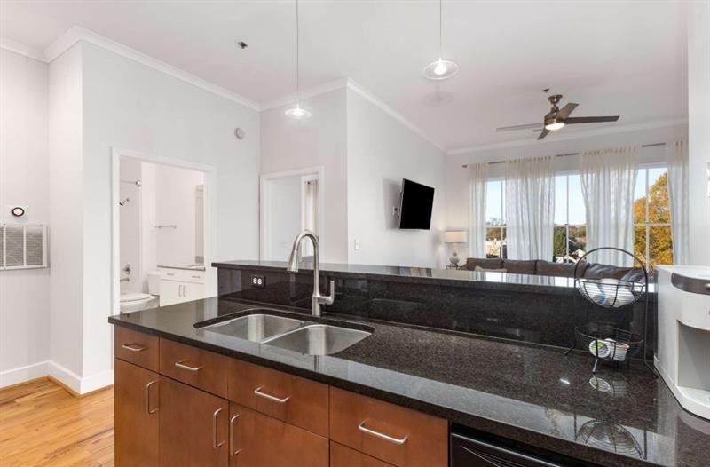 384 Ralph McGill Boulevard Northeast, Unit 313 Atlanta, GA 30312 - Photo 7 of 31 a kitchen with granite countertop a sink and white cabinets
