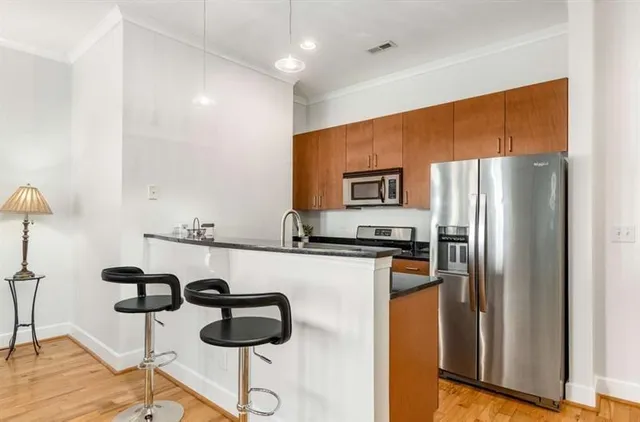 a kitchen with stainless steel appliances granite countertop a sink and a refrigerator
